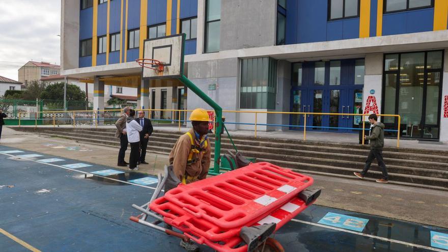 Un operario transporta unas vallas durante las obras de A Lomba, ayer.