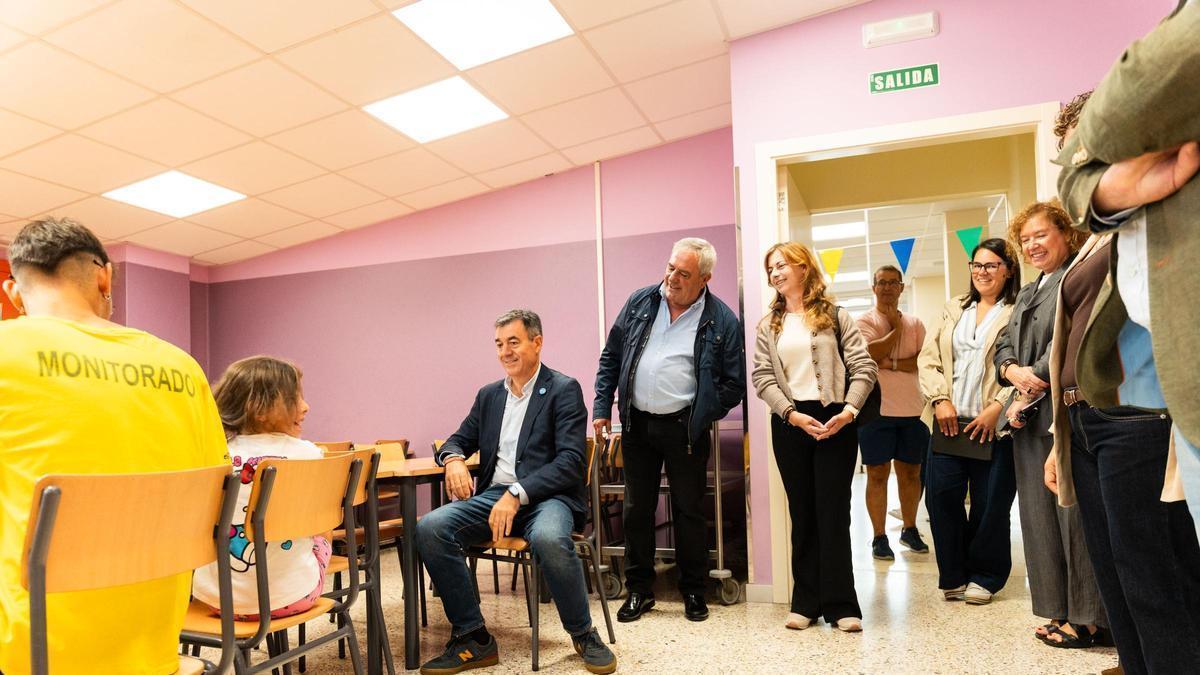 El conselleiro de Educación, sentado, junto al alcalde de Carral en la visita al colegio Vicente Otero Valcárcel.