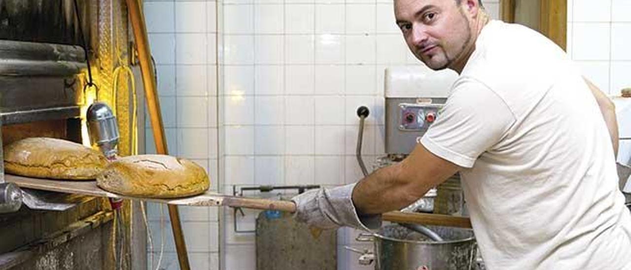 Juan Fullana con el pan saliendo del horno.