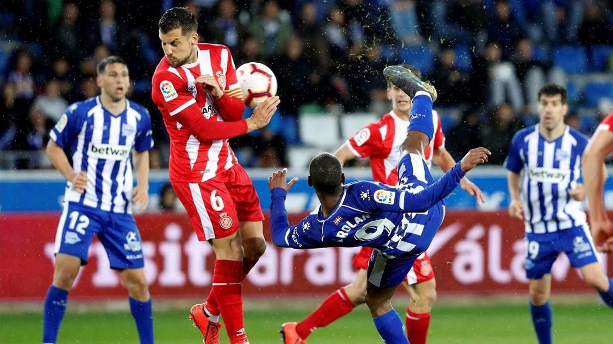 El delantero uruguayo del Alavés Diego Rolan remata ante el centrocampista del Girona Alex Granell