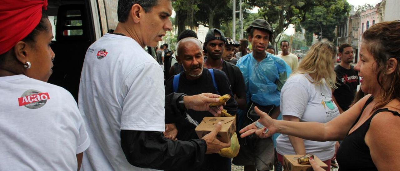 Voluntarios de Ação pela Cidadania reparten 100 raciones de comida en el centro de Río de Janeiro.