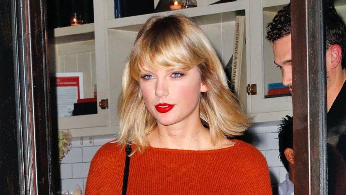 Taylor Swift con jersey y labios rojos