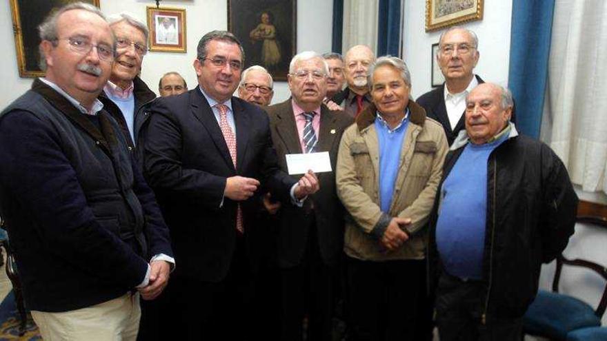 Antiguos portapasos del Nazareno le entregan el donativo a los miembros de la Junta de Gobierno del Hospital de Caridad