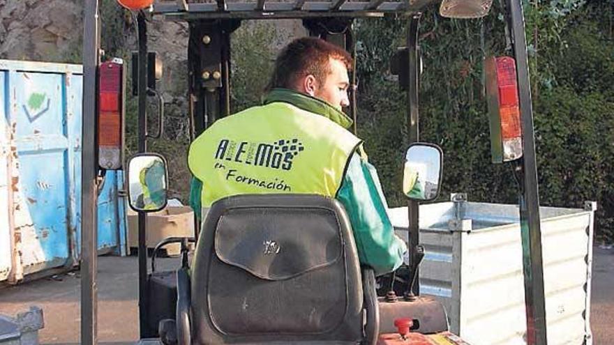 Un alumno aprende a manejar una carretilla elevadora.