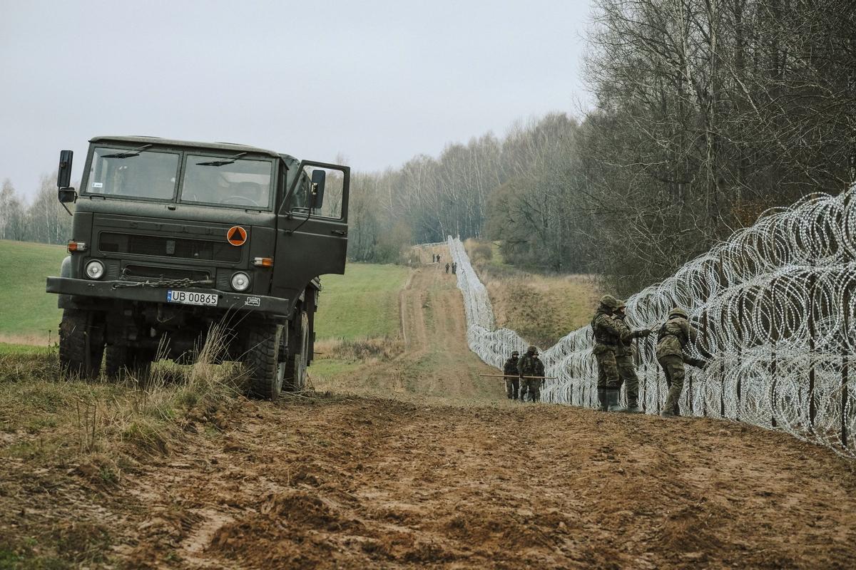 Soldados del ejército polaco arreglan bobinas de alambre de púas en una valla a lo largo de la frontera polaca, con el enclave ruso de Kaliningrado, cerca de Zerdziny, Polonia