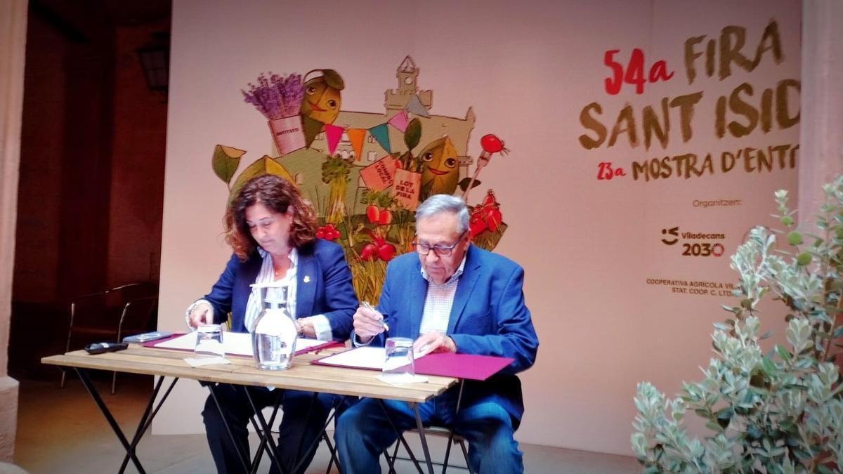 La alcaldesa de Viladecans, Olga Morales, y el presidente de la Cooperativa Agrícola de Viladecans, Carles Faura, firman el acuerdo de colaboración para celebrar la tradicional 'Concurs Exposició de Fruits del Camp' en la 54ª edición de la Fira de Sant Isidre.