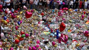 Espectadores del tributo floral por las víctimas del atentado en el Manchester Arena de 2017 unos días después de que ocurriera.