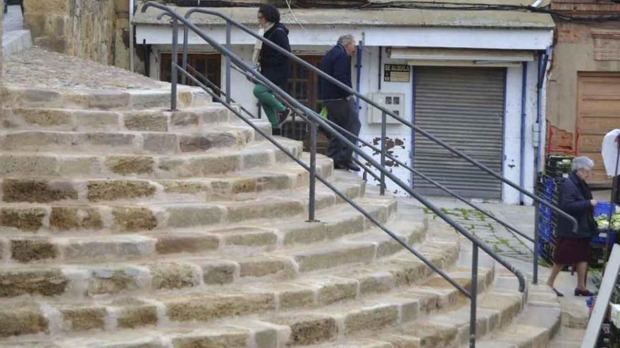 Varias personas, ayer por la mañana subiendo y bajando por la escalinata de la plaza del Grano.