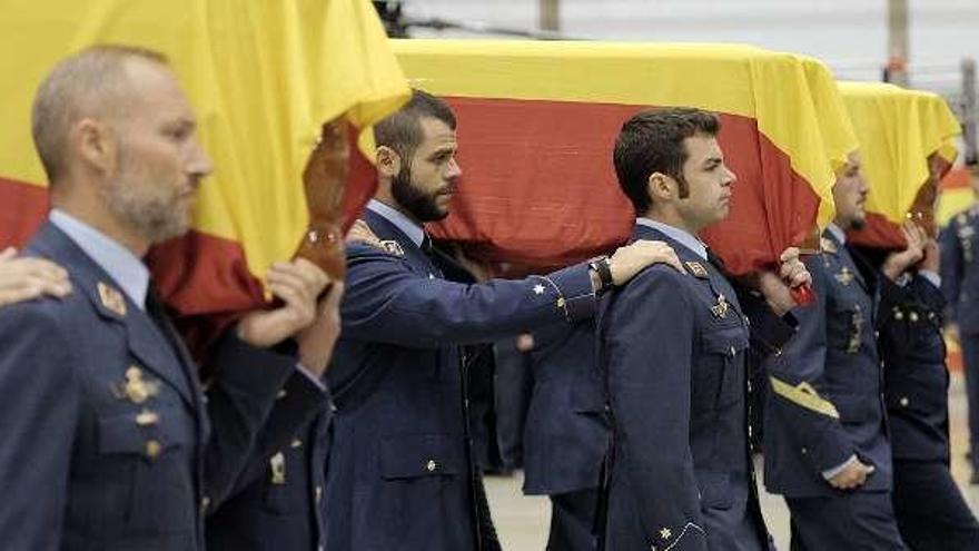 Compañeros portan los féretros de los fallecidos.