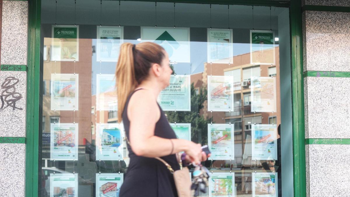 Imagen del escaparate de una inmobiliaria con anuncios de viviendas en venta y alquiler.
