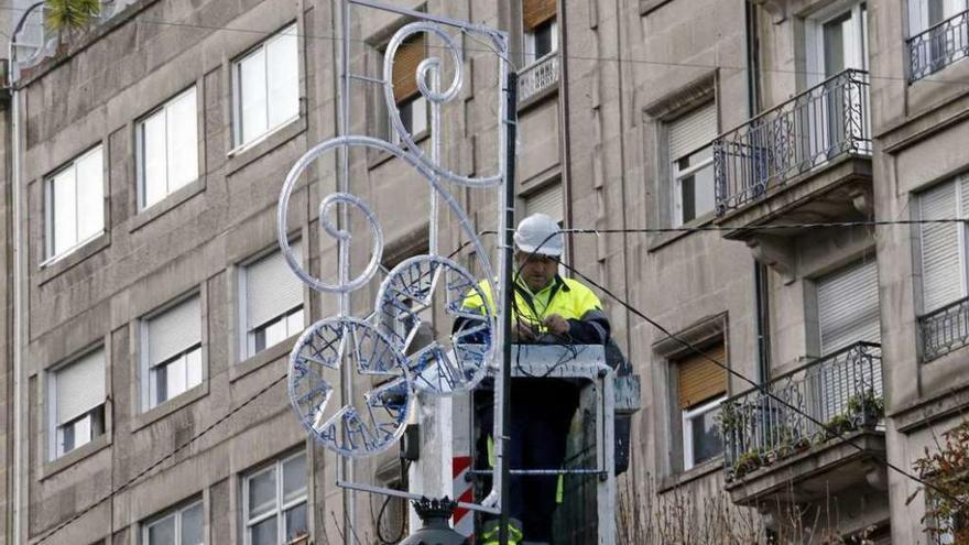 Un operario instala las luces de Navidad en el centro de la ciudad. // Marta G. Brea
