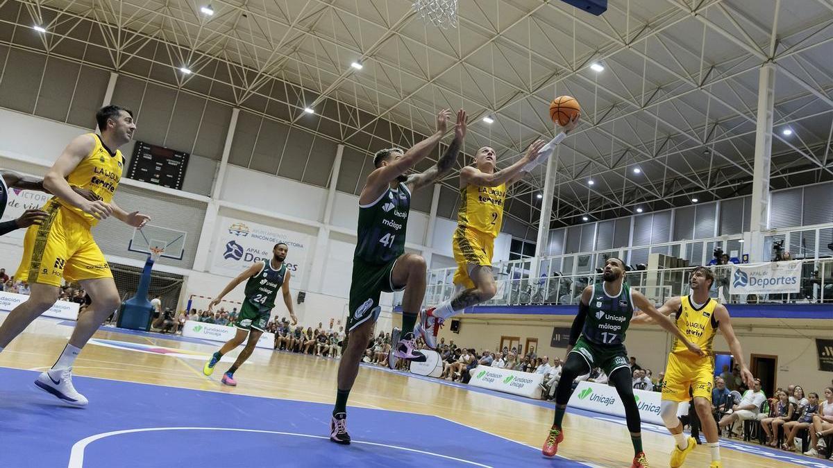 Kyle Guy penetra a canasta ante la defensa de Willy Hernangómez, en el amistoso Unicaja-Canarias.