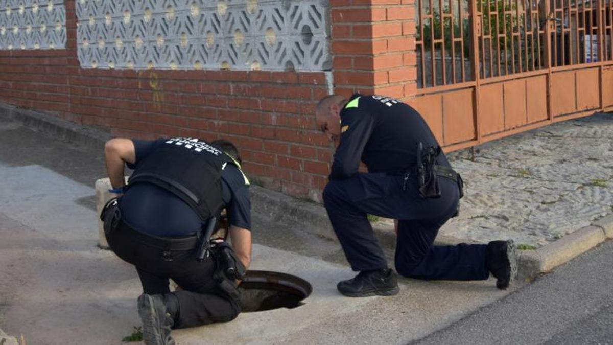 Dos agents de la Policia Local de Sant Salvador de Guardiola en una de les entrades del clavegueram del Calvet