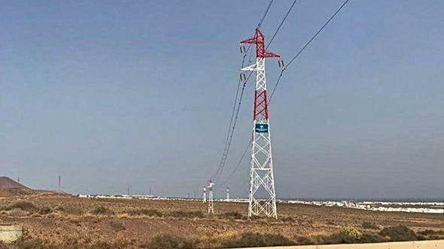 Torretas eléctricas pintadas de rojo a su paso por la zona de Argana en Arrecife.