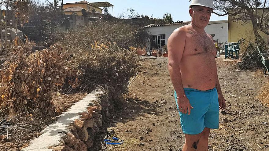 Arriba, Petra y Oliver observan los daños de su casa en Camino del Torreón tras el control del incendio en La Palma. A la izquierda, Ernesto, uno de los afectados por el fuego, señala la dirección de las llamas. A la derecha, otro afectado, Alejandro, trata de salvar lo que pueda en su vivienda. | ramón pérez