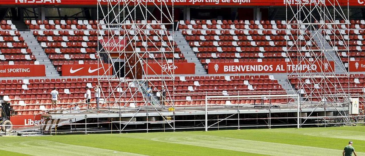 Operarios montan ayer el escenario en el estadio de El Molinón.