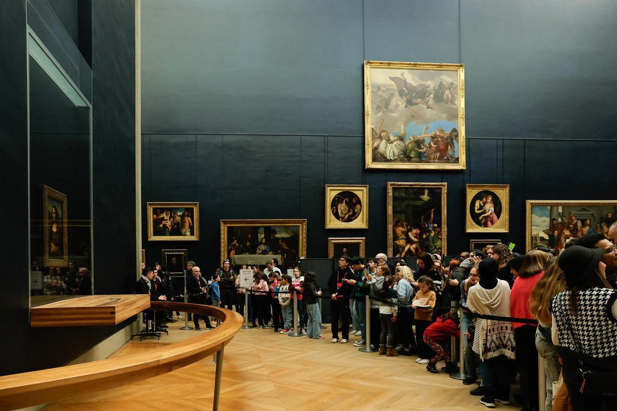 Aglomeración de visitantes frente a la Mona Lisa de Leonardo da Vinci, en el Museo del Louvre.