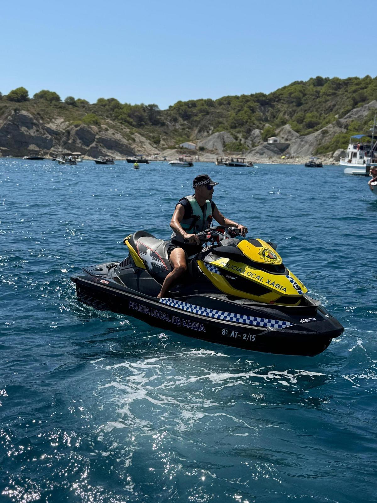 El agente que patrulla con la moto acuática acude inmediatamente a exigir a los infractores que retiren el ancla de las praderas