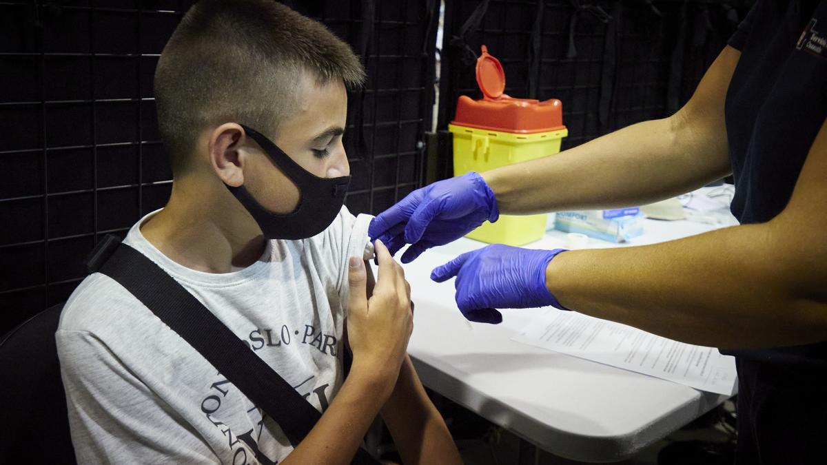 Un adolescente de 12 años recibe la primera dosis de la vacuna de Pfizer.