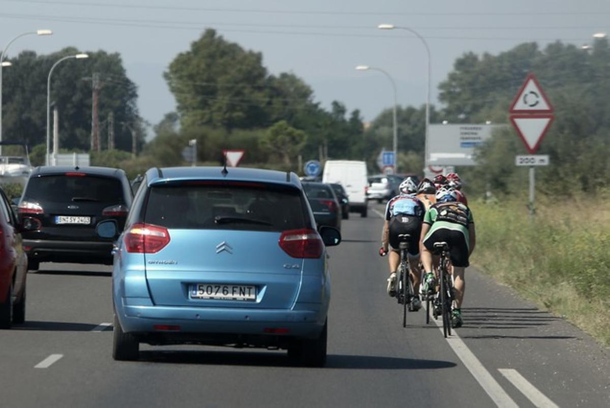 Automobilistes i ciclistes comparteixen carretera a Castelló d’Empúries.