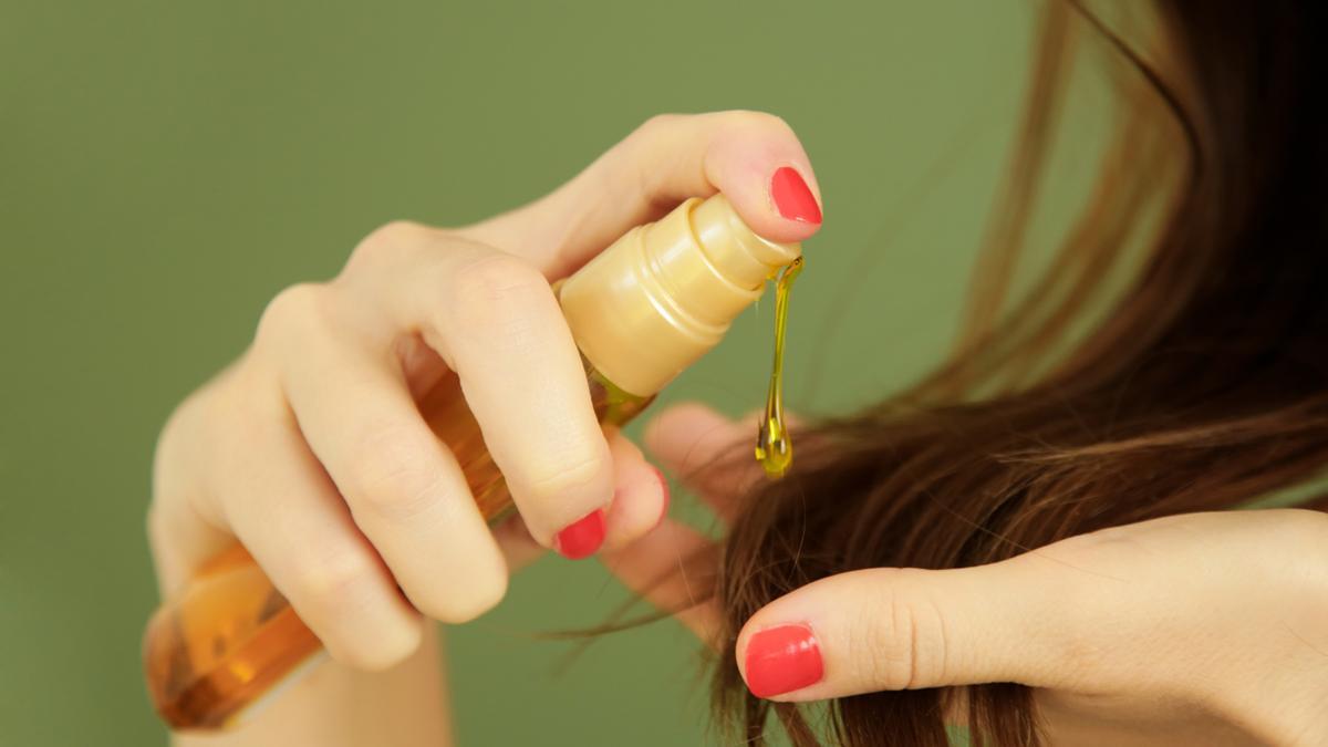 Mujer aplicando aceite capilar