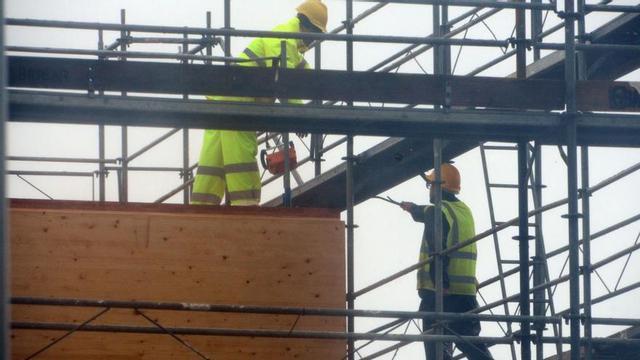 Empleados de la construcción, ayer en la comarca, bajo un toldo para evitar la lluvia.   | // GONZALO NÚÑEZ
