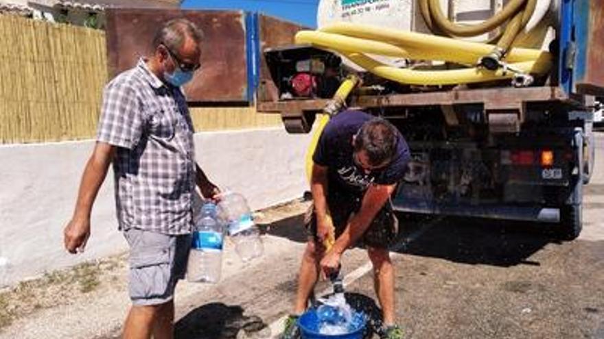 Un residente de Costa Nova llena garrafas en el camión cisterna enviado por el ayuntamiento.