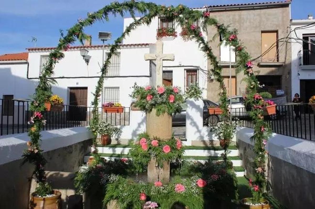 Los habitantes de Cabeza la Vaca velan sus cruces adornadas con flores en una tradicional fiesta local