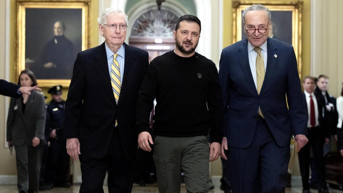 El presidente de Ucrania, Volodímir Zelenski, camina entre el senador republicano Mitch McConnel y el demócrata Chuck Schumer, antes de la reunión en el Senado.