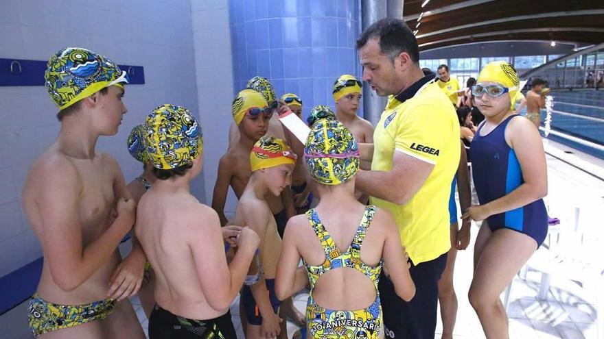 Javier Hurlé, director técnico del Club Natación Ciudad de Oviedo, habla con un grupo de nadadores de categoría benjamín.