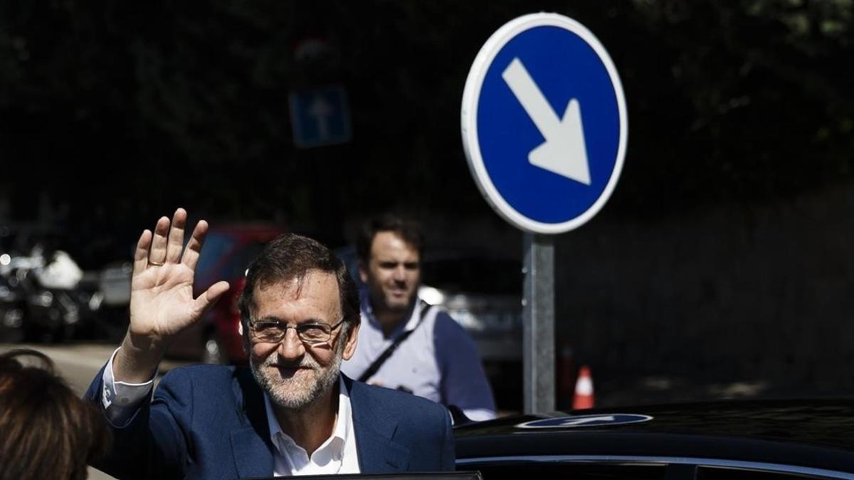 Rajoy saluda tras ir a votar, este domingo en Madrid.