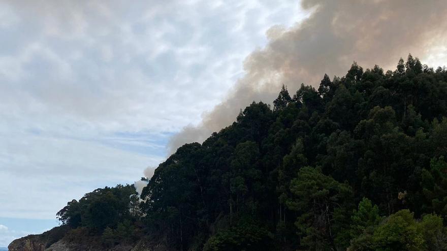 Un incendio en Veigue moviliza a brigadas forestales y a un helicóptero de la Xunta