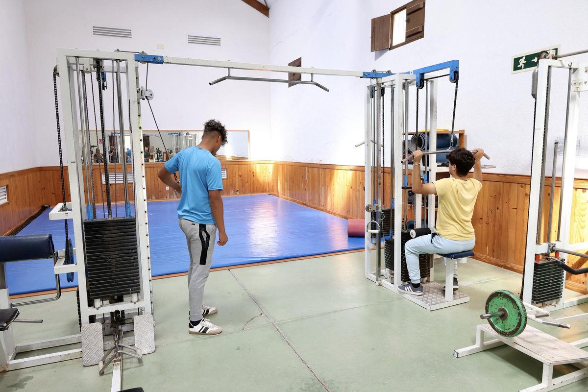 Dos chicos hacen ejercicio en el gimnasio que hay en el centro de La Zarza.