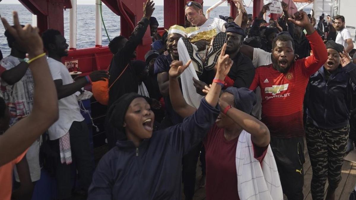 Los inmigrantes del 'Ocean VIking' celebran que van a poder desembarcar este martes en Italia.