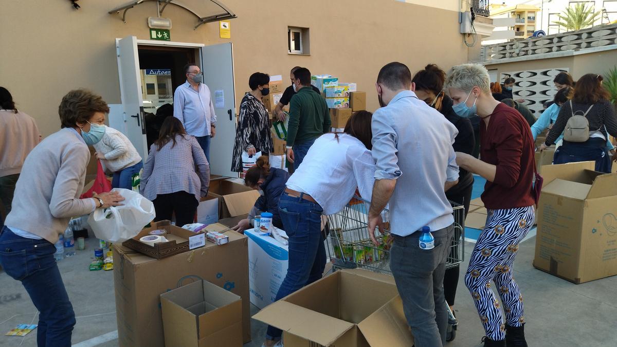 Los voluntarios meten en cajas la ropa de abrigo, la comida y los medicamentos