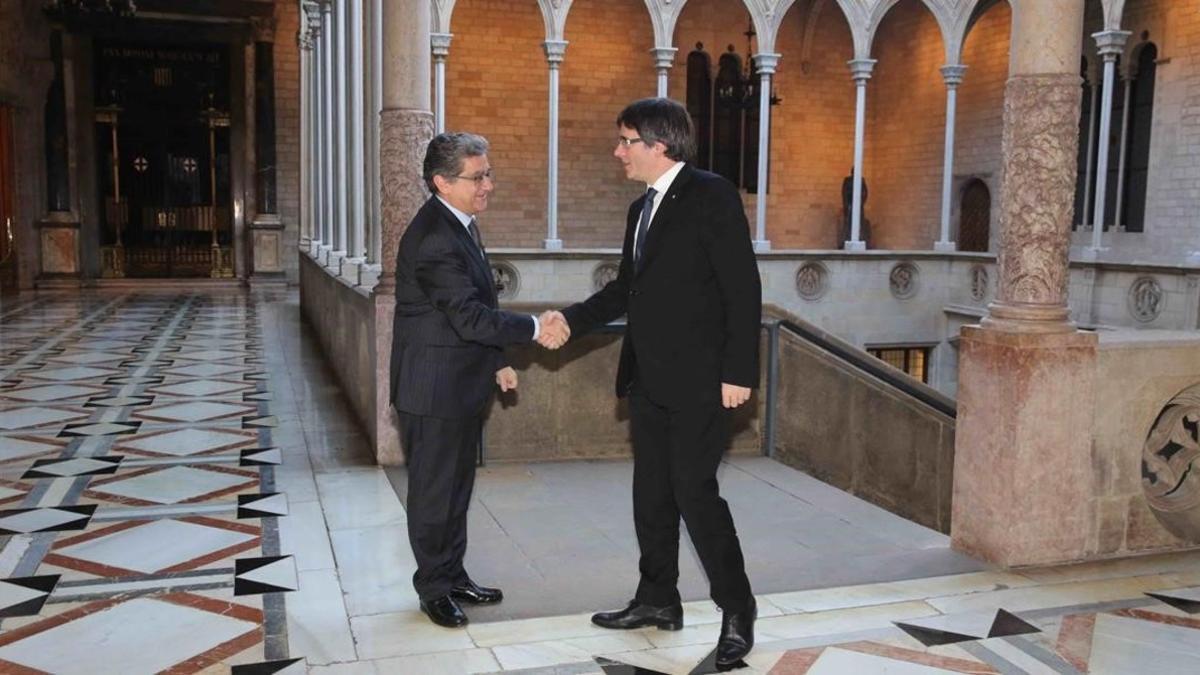 El 'president', Carles Puigdemont, saluda al delegado del Gobierno en Catalunya, Enric Millo, en el Palau de la Generalitat