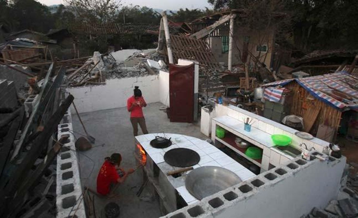 Dues noies bullen aigua en una cuina parcialment destruïda, al costat de la qual han construït una petita cabanya per refugiar-se de la intempèrie a Yingjiang (Japó).