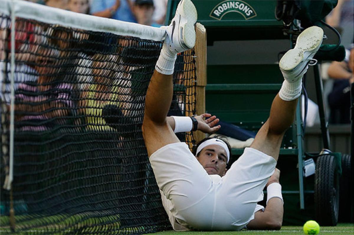Rafael Nadal cau a terra després de perdre un punt davant el txec Lukas Rosol, a Wimblendon.