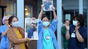 LONDON, ENGLAND  - APRIL 30: Medical workers hold up pictures of their friend and colleague Ken Lambatan who died of COVID-19 as they ’Clap for Our Carers’ outside Kingston Hospital on April 30, 2020 in London, England United Kingdom. Following the success of  the Clap for Our Carers campaign, members of the public are being encouraged to applaud NHS staff and other key workers from their homes at 8pm every Thursday. The Coronavirus (COVID-19) pandemic has infected over 3 million people across the world, claiming at least 26,711 lives in the U.K. (Photo by Chris Jackson/Getty Images) ***BESTPIX***