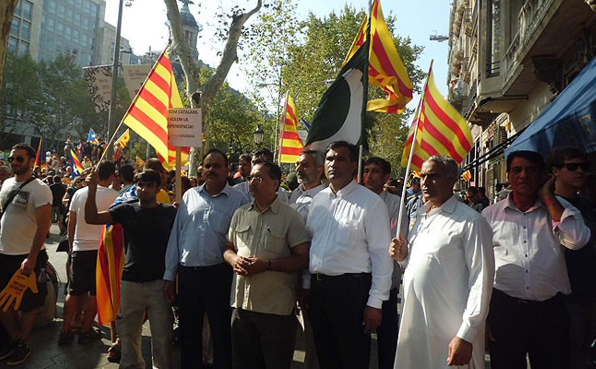 Un colectivo de inmigrantes se manifiesta por la independencia de Catalunya con ’senyeras’ y una pancarta que dice Som catalans. Volem la independència