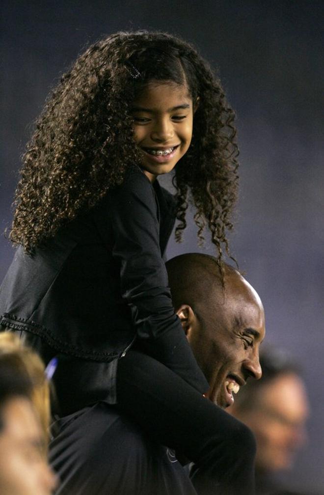 Kobe Byran en el lateral de la pista con su hija Gianna Maria-Onore Bryant subida a hombros antes del partido amistoso entre Estados Unidos y China en el Qualcomm Stadium el 10 de abril del 2014.