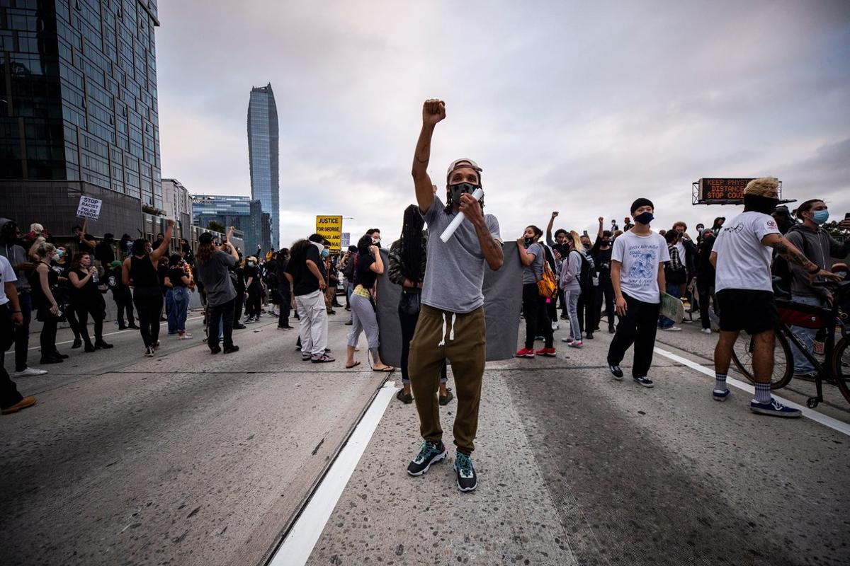 -FOTODELDÍA- EPA9988. LOS ÁNGELES (ESTADOS UNIDOS), 30/05/2020.- Un ciudadano alza el puño durante una manifestación convocada tras la muerte del afroamericano George Floyd a manos de la policía el lunes pasado en Mineápolis, este sábado en la Ruta 110 de Los Ángeles, California, Estados Unidos. Los disturbios raciales por la muerte del afroamericano George Floyd a manos de la policía el lunes pasado en Mineápolis, se extendieron por ciudades de todo Estados Unidos, con incendios, saqueos y enfrentamientos entre manifestantes y agentes antidisturbios. Floyd, de 40 años, falleció el lunes cuando era detenido bajo la sospecha de haber intentado usar un billete falso de 20 dólares en un supermercado. EFE/Etienne Laurent