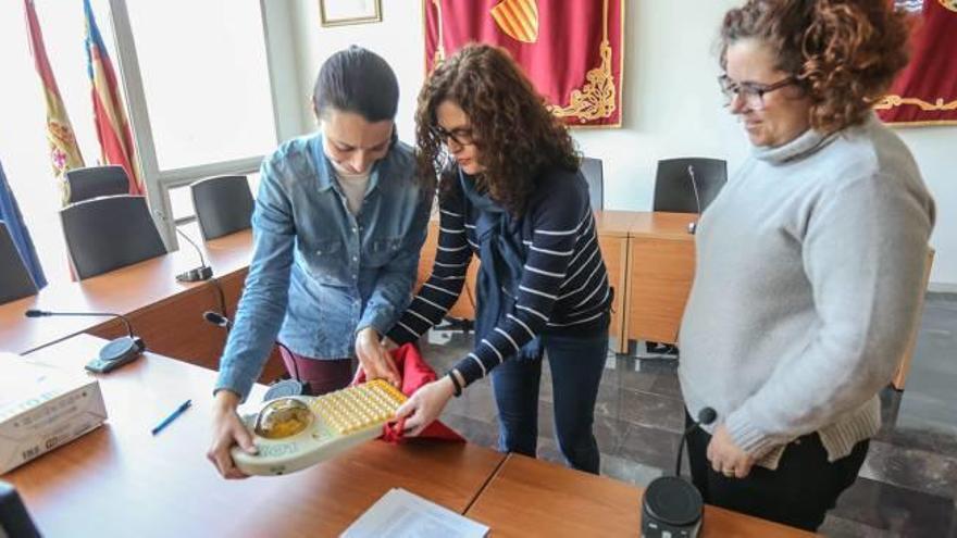 Las trabajadoras del Ayuntamiento meten las bolas del bingo en la bolsa antes de que una de ellas fuera extraida al azar.