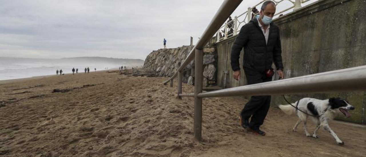 Un hombre abandona la playa de Salinas por la escalera del Espartal, totalmente cubierta de arena en su tercio inferior. | Ricardo Solís | R. S.