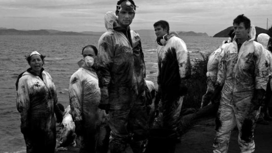 Un grupo de voluntarios, con los trajes llenos de chapapote, en la isla de Ons.  // Iñaki Abella