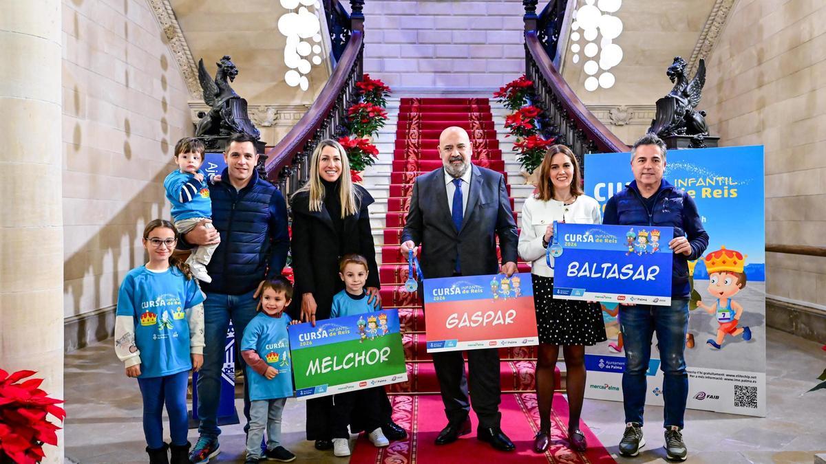 Jaime Martínez Llabrés, alcalde de Palma, posa con niños y padres que participan en la Cursa Infantil de Reis, portando camisetas de la carrera y carteles con los nombres de los Reyes Magos.