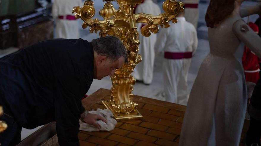 Un cofrade se afana en secar
uno de los tronos tras la procesión
de Domingo de Ramos.  loyola pérez de villegas