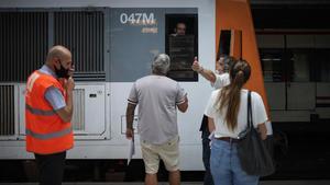 Un pasajero se queja a un maquinista de Renfe, durante la jornada de huelga, en la estación de Sants.