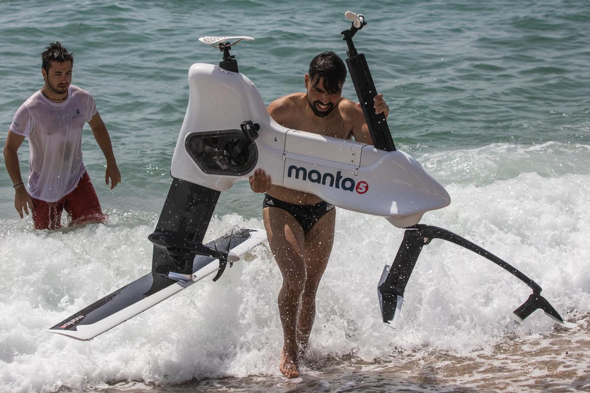 Adrià Mercader, gerente de Manta5.cat, saca la hidrobici del agua frente al Club Náutico Bétulo de Badalona.