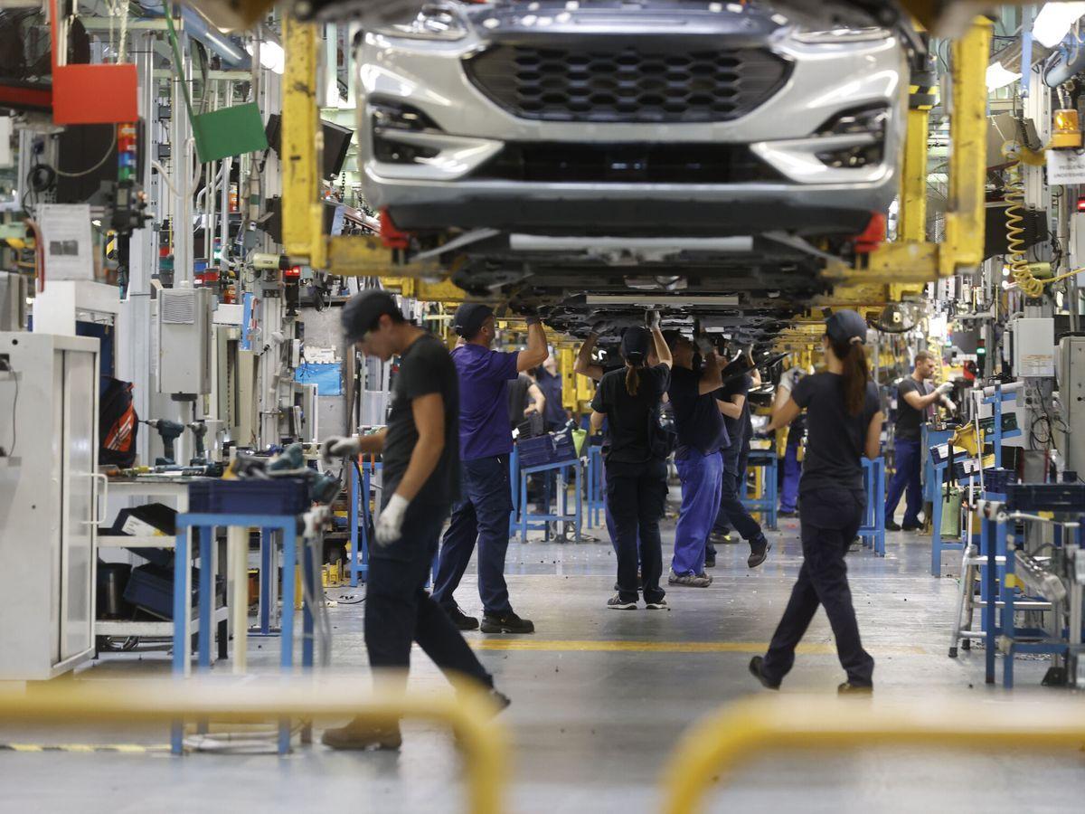 Trabajadores en una cadena de montaje de vehículos de una planta industrial, el sector que ha registrado el mayor descenso del paro en el último mes.